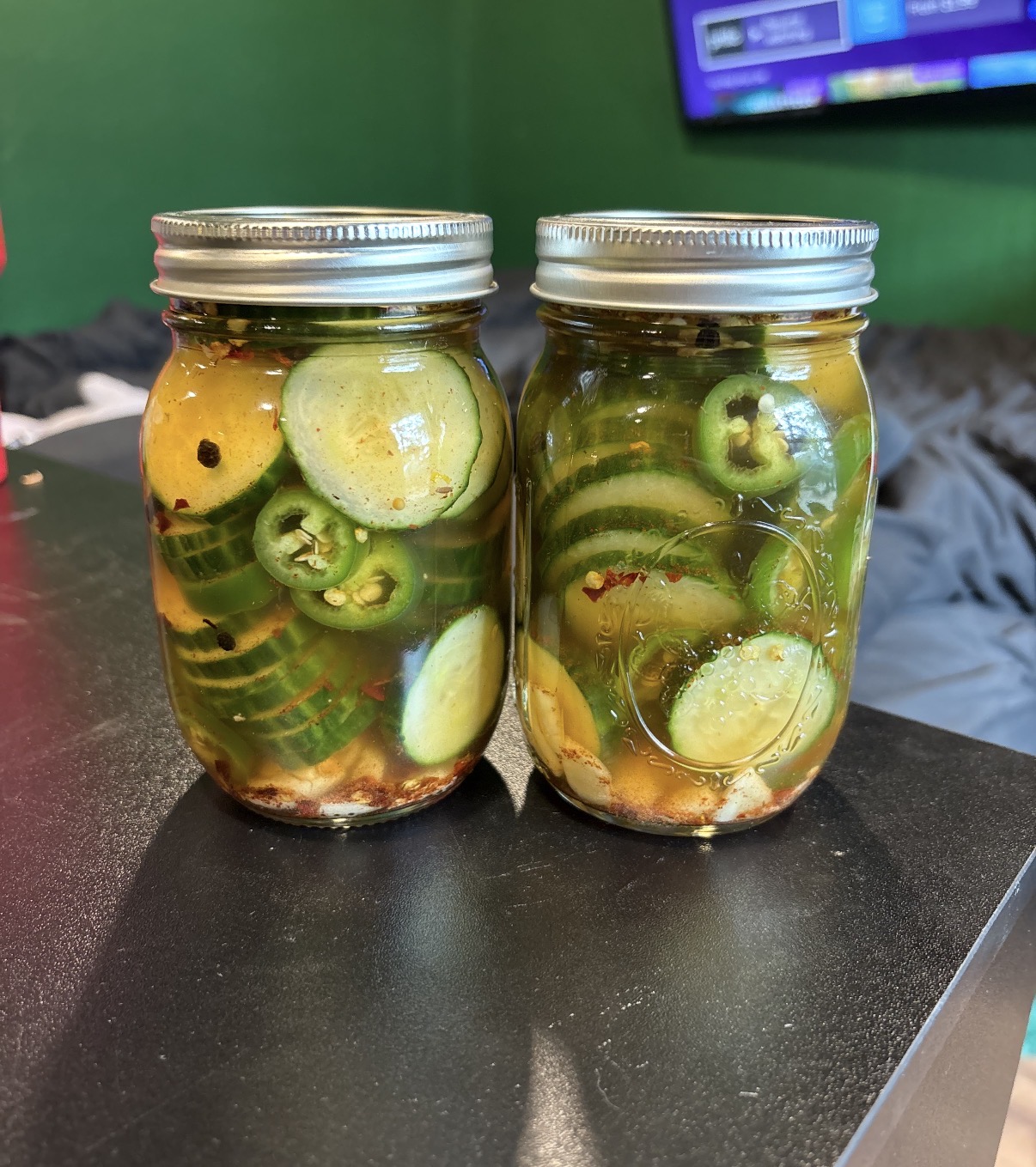 Jars of spicy cucumber and jalapeño pickles